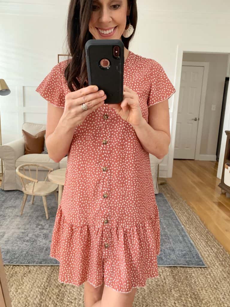 A mirror selfie of a woman wearing a mauve and white polka-dot button down dress with cap sleeves from Amazon.