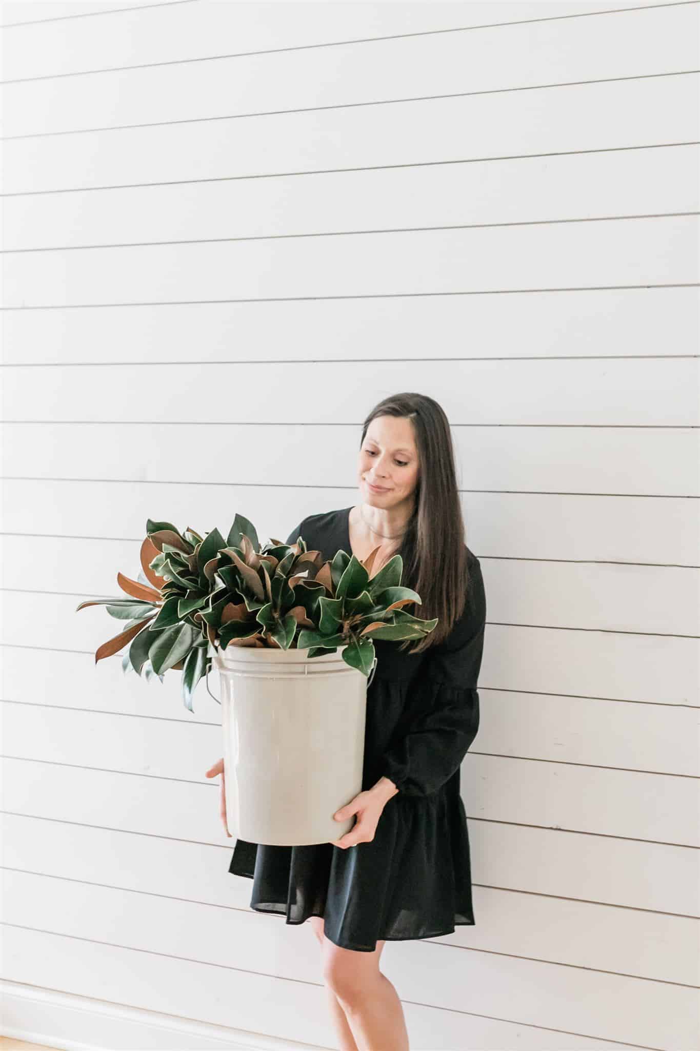 A bucket full of live magnolia clippings, soaking in water! I can't wait to make a stunning DIY live magnolia wreath with these clippings.