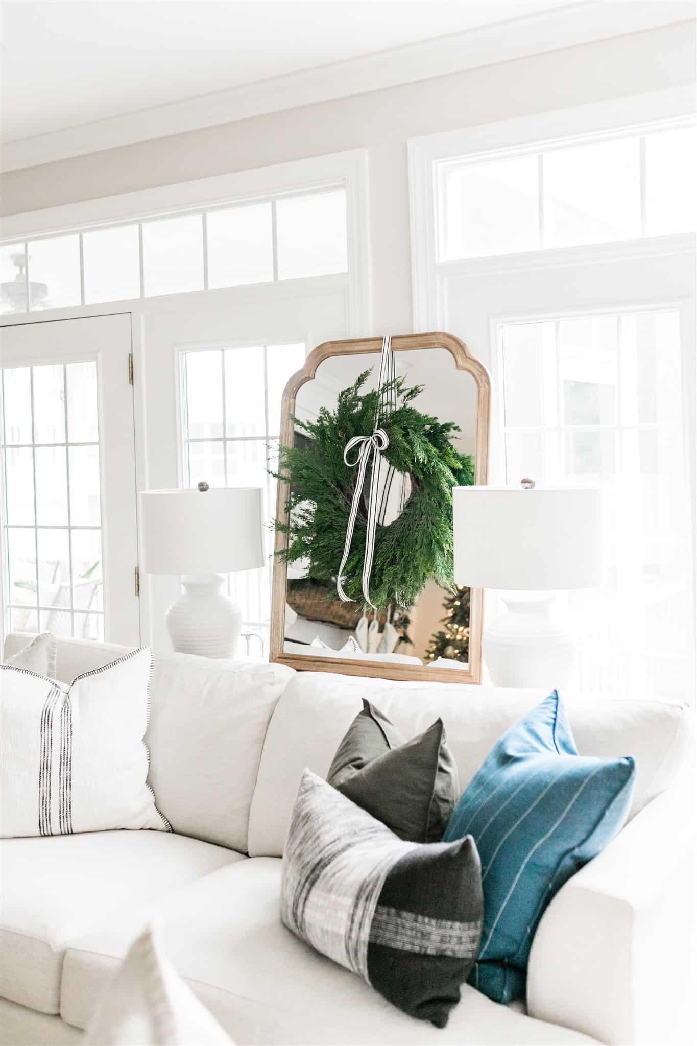 How to decorate your mantel for Christmas with simple garland, black and white striped ribbon, bells, and neutral stockings. Also, a look at our Christmas decor from last year. A simple and neutral Christmas decor inspiration post. #neutralchristmas #christmasdecor #simplechristmas #christmasinspiration #cedargarland