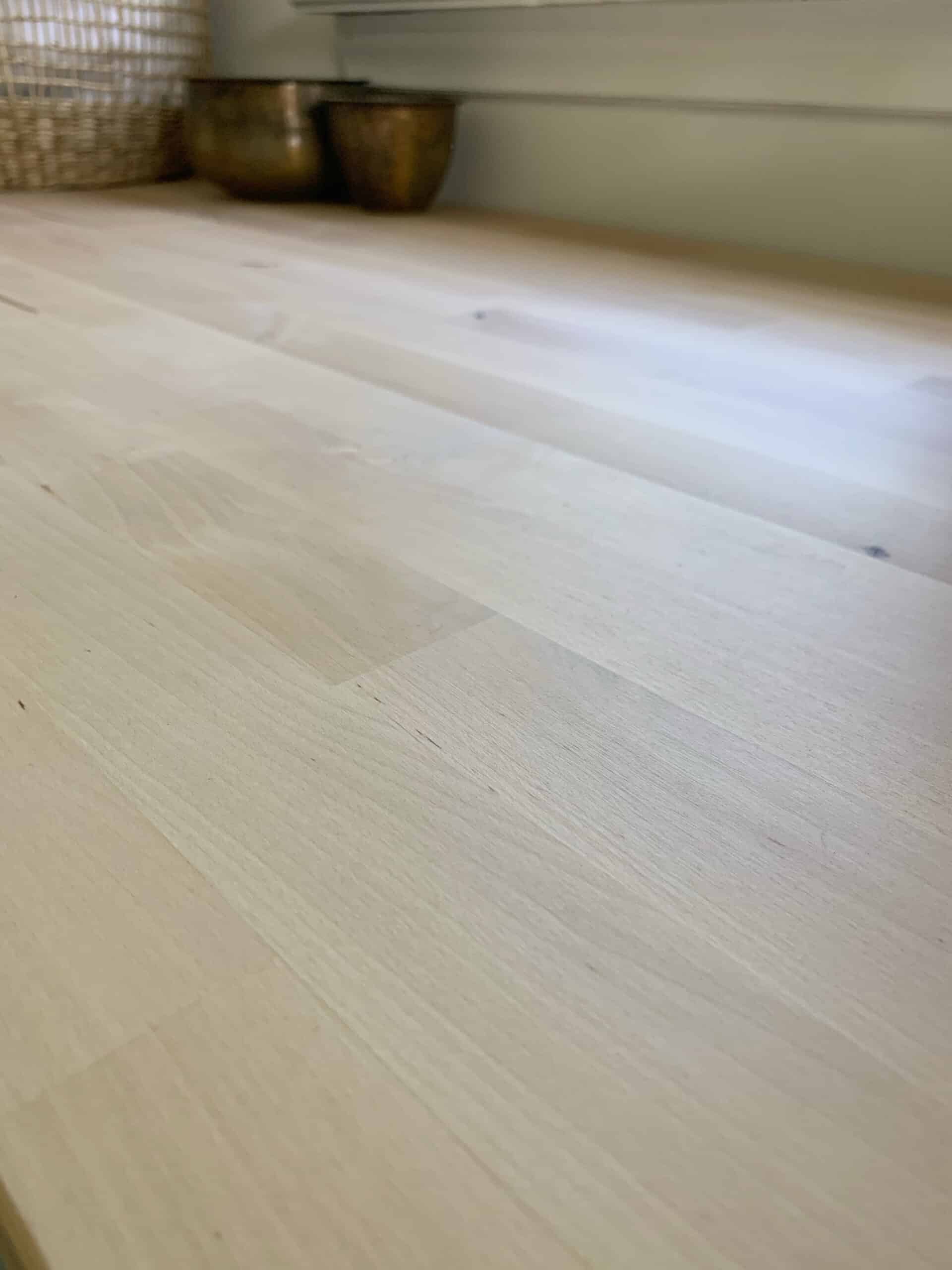 How to seal your new butcher block countertop with a natural finish - a close up look at the all natural wood grain in our new laundry room butcher block countertop #laundryroom #butcherblock #butcherblockcountertop #countertop #diycounters #coastalhome #coastallaundryroom #vintageruglaundryroom #vintagerug #paintedtile #paintedfloors