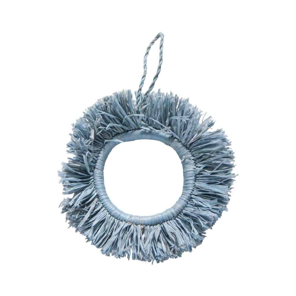A simple tasseled fabric ring ornament in a coastal blue color.