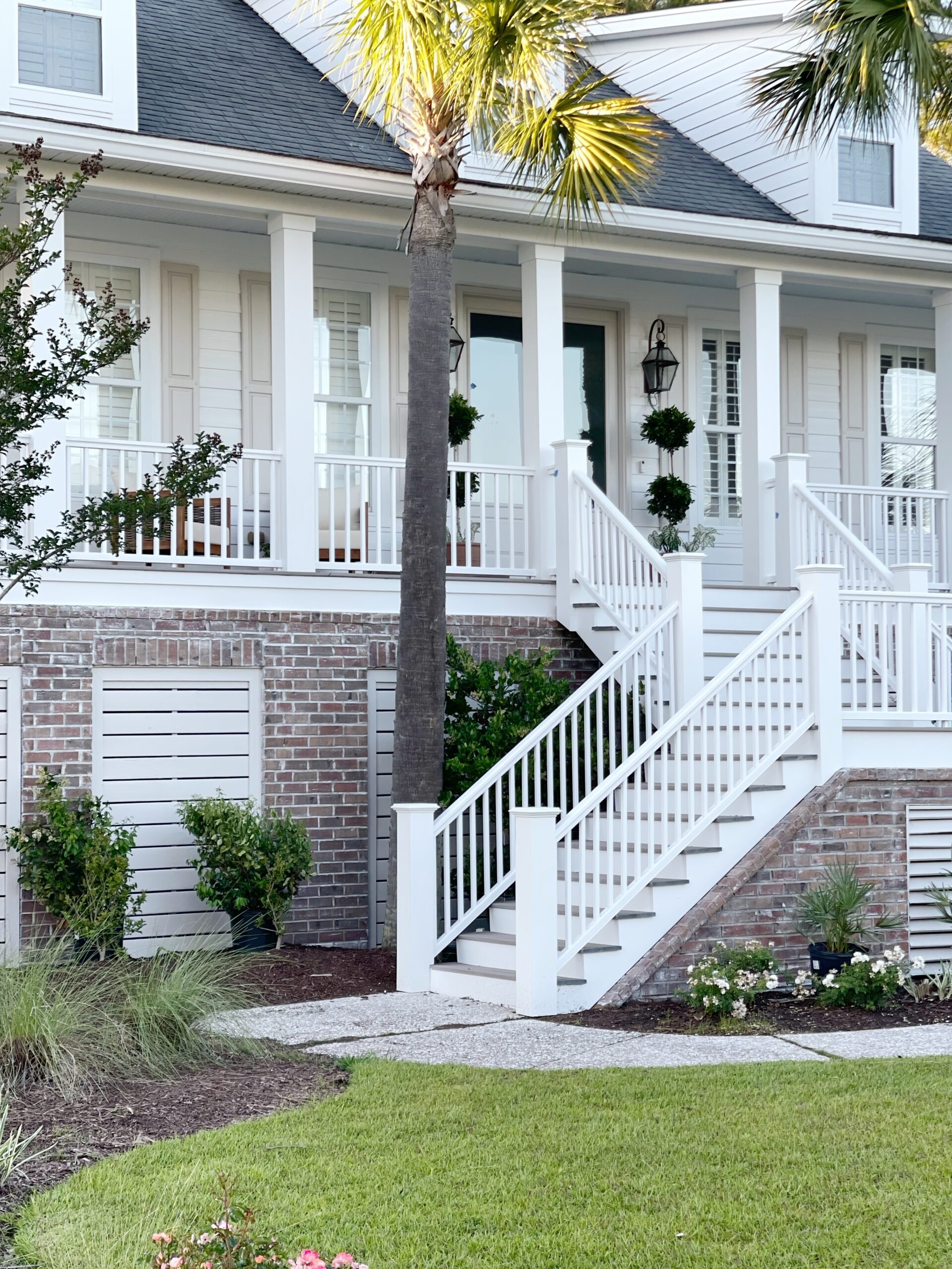 Coastal front porch makeover with white washed brick and square columns.